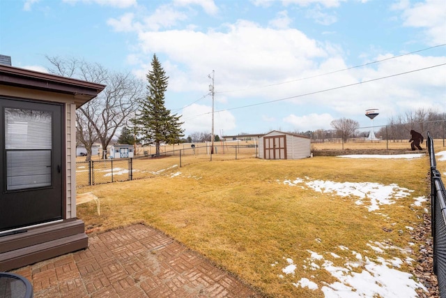 view of yard with an outbuilding, a shed, a patio area, and fence