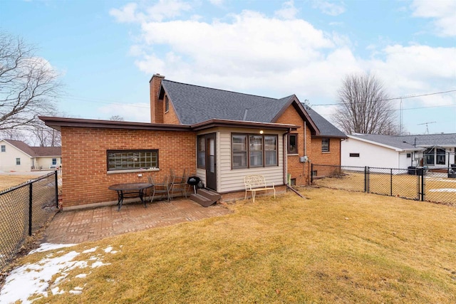 rear view of house with a lawn, a fenced backyard, a chimney, a patio area, and brick siding