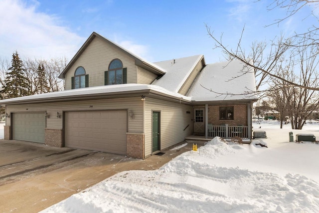 view of front of home featuring a garage, driveway, and brick siding