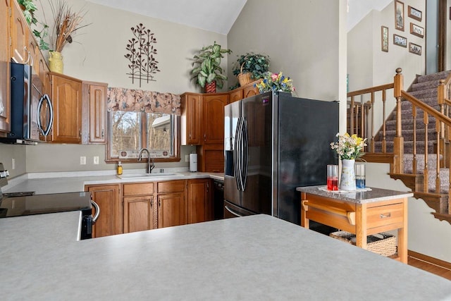 kitchen featuring range with electric cooktop, a sink, black fridge with ice dispenser, light countertops, and stainless steel microwave