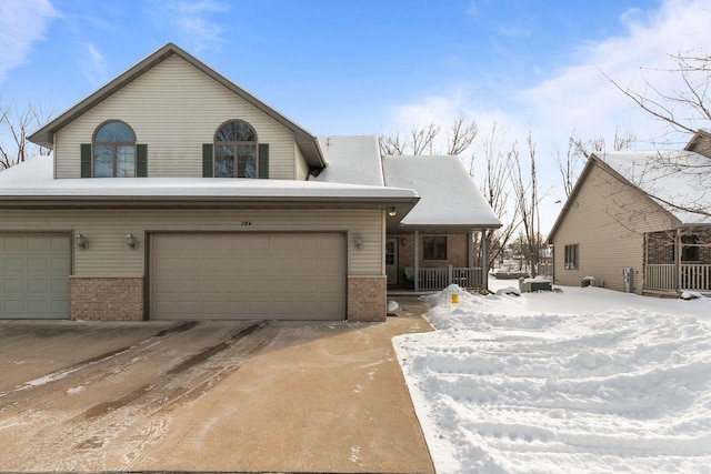 view of front of house featuring a garage, covered porch, and brick siding