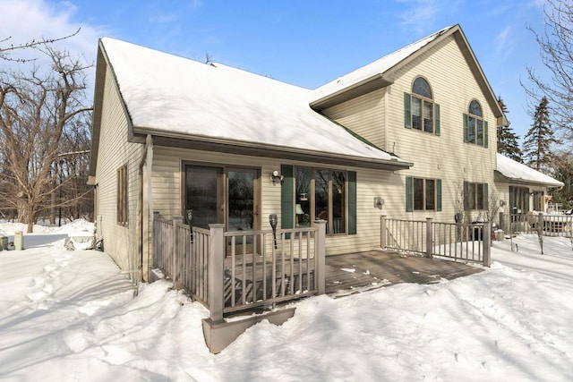 snow covered house featuring a porch