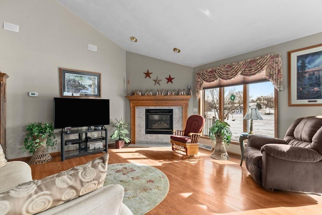 living room featuring high vaulted ceiling, light wood finished floors, and a premium fireplace