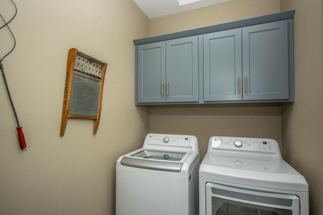 washroom featuring cabinet space and washer and clothes dryer