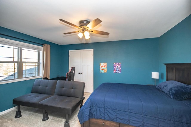 carpeted bedroom featuring baseboards and a ceiling fan