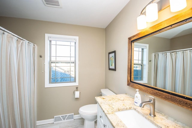 bathroom featuring toilet, baseboards, visible vents, and vanity