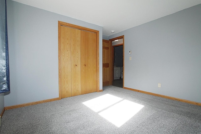 unfurnished bedroom with a closet, baseboards, and carpet flooring