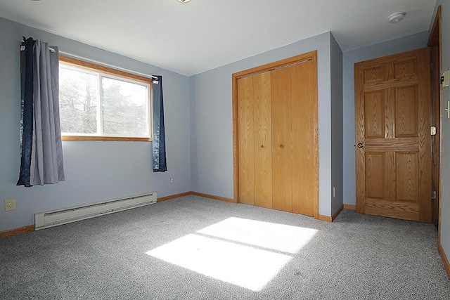 unfurnished bedroom with baseboards, carpet, a baseboard heating unit, and a closet