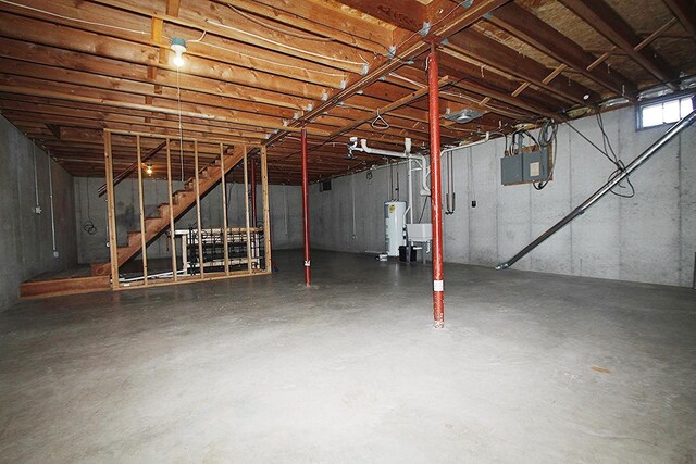 below grade area with electric panel, water heater, and stairway