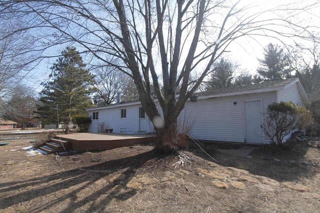 rear view of property featuring a wooden deck