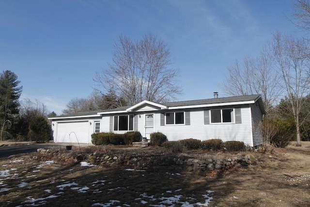 single story home featuring a garage and aphalt driveway