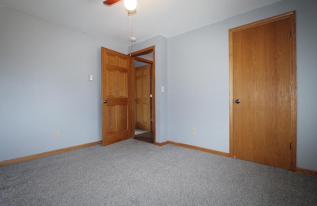 carpeted empty room featuring ceiling fan and baseboards