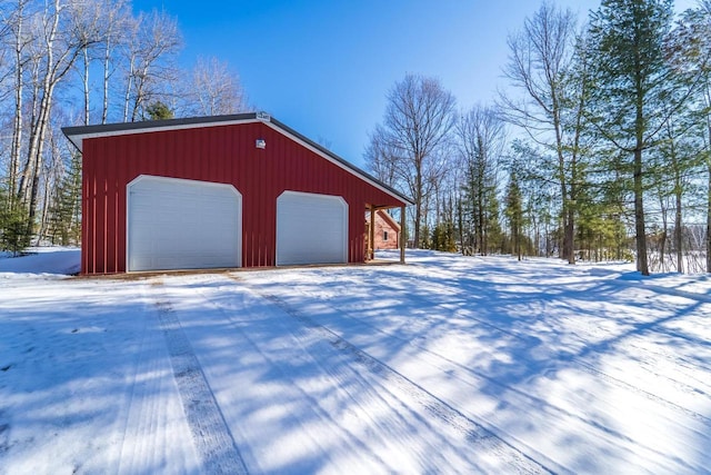 snow covered garage featuring a detached garage