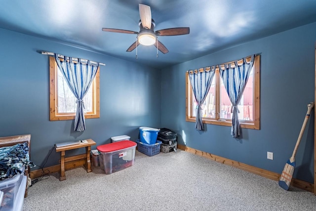 interior space featuring ceiling fan, carpet floors, and baseboards