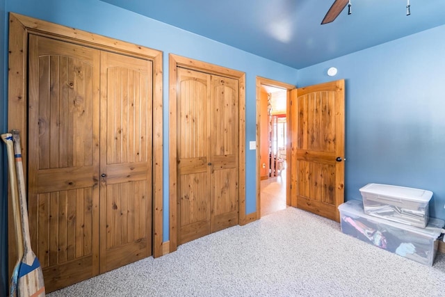 interior space with a ceiling fan and two closets