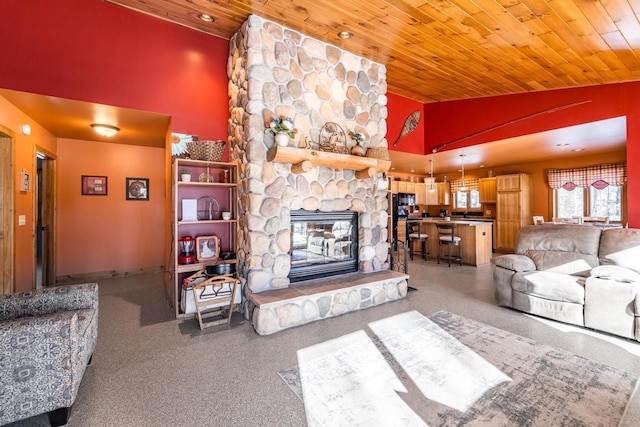 living area featuring high vaulted ceiling, wood ceiling, and a fireplace