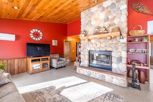 living room with wainscoting, lofted ceiling, wooden ceiling, a stone fireplace, and a wall mounted AC