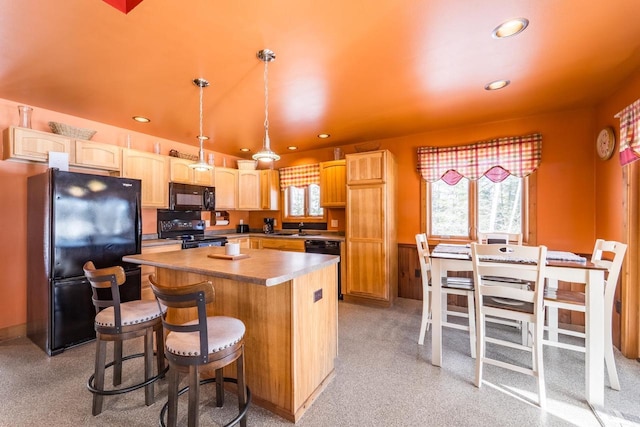 kitchen with a center island, hanging light fixtures, black appliances, light brown cabinets, and a sink