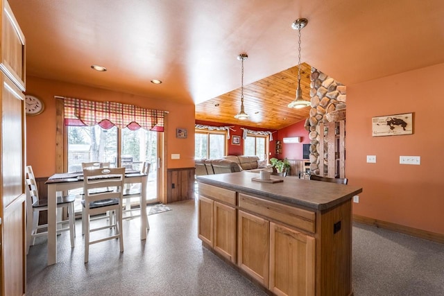 kitchen with open floor plan, plenty of natural light, dark countertops, and pendant lighting