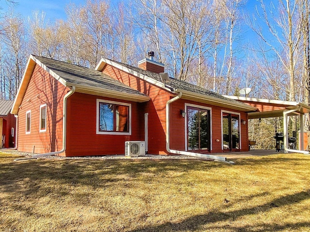 back of house featuring a patio area, a yard, ac unit, and a chimney