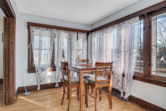 dining area featuring light wood finished floors and baseboards