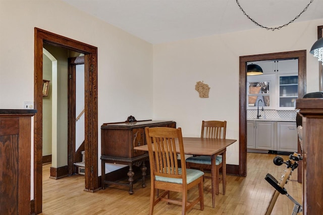 dining room featuring light wood-style flooring and baseboards