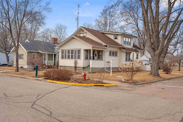 bungalow-style home with a shingled roof