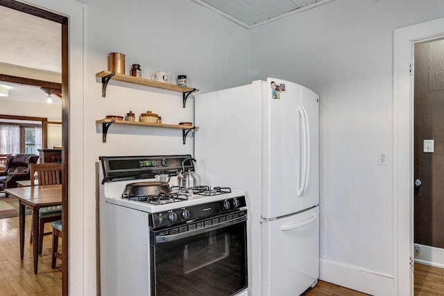 kitchen featuring range with gas stovetop, freestanding refrigerator, and light wood-style flooring