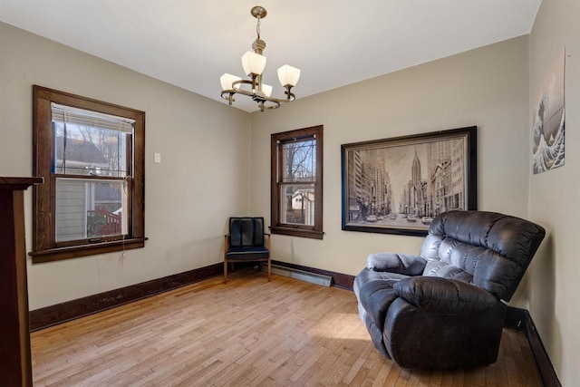 sitting room featuring light wood finished floors, a baseboard radiator, plenty of natural light, and baseboards