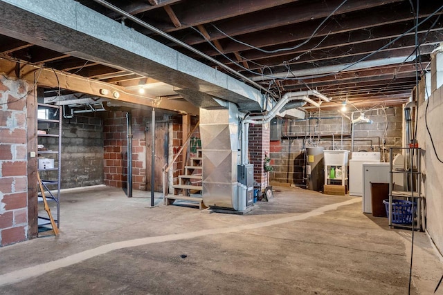 unfinished below grade area featuring electric panel, heating unit, stairs, washing machine and dryer, and water heater