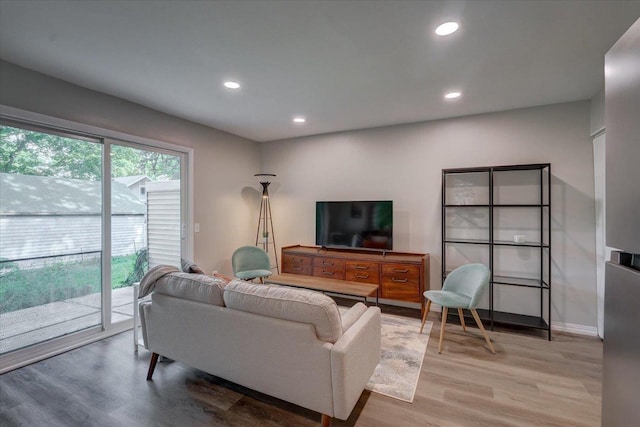 living area featuring baseboards, light wood-style flooring, and recessed lighting