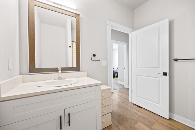 bathroom featuring wood finished floors, vanity, and baseboards