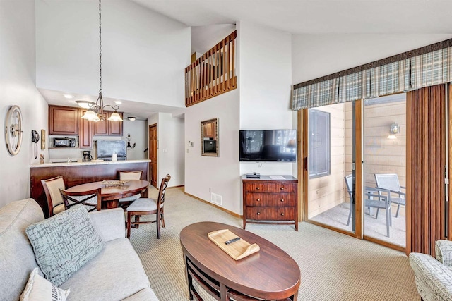 living area featuring a chandelier, light colored carpet, high vaulted ceiling, and baseboards