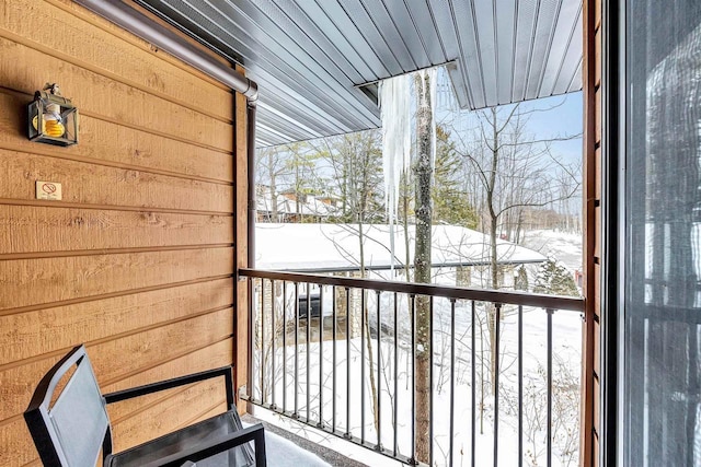 view of snow covered back of property