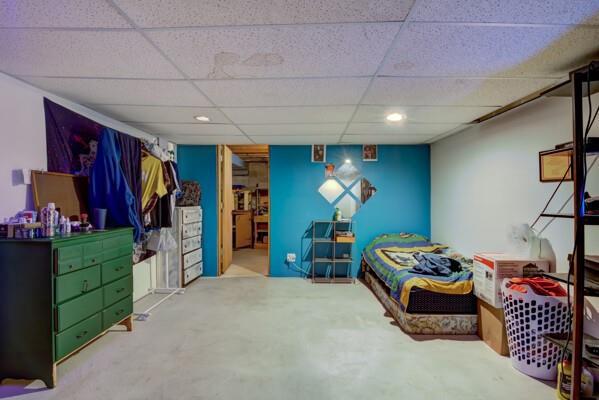 bedroom with concrete floors and a paneled ceiling