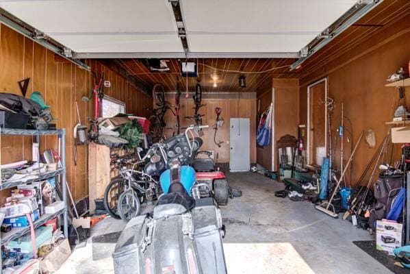 garage featuring wooden walls and a garage door opener