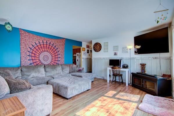 living room with wood finished floors and wainscoting