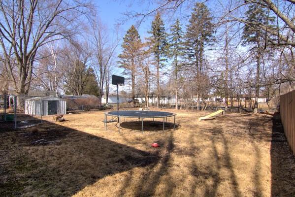 view of yard with a trampoline and fence