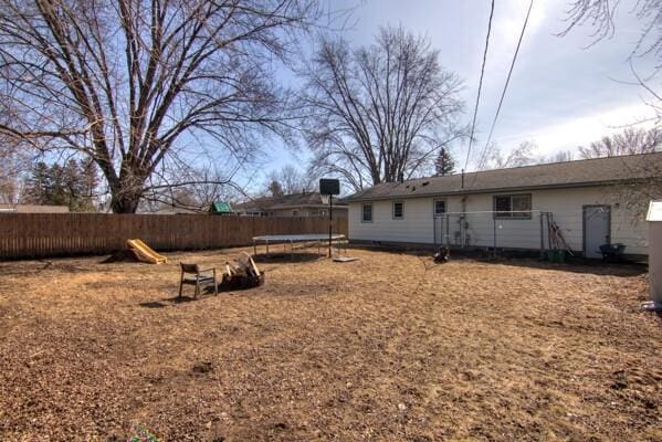 view of yard with a trampoline and fence