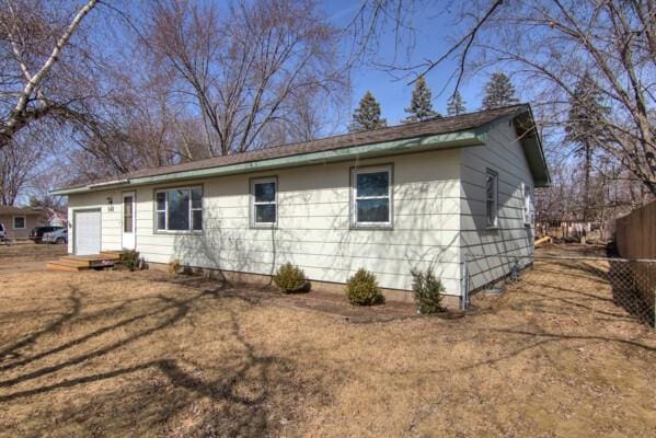 view of side of property with a garage and fence