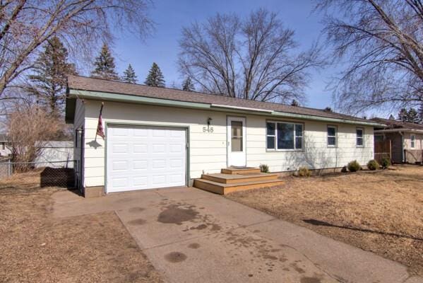 single story home featuring driveway, a garage, and fence