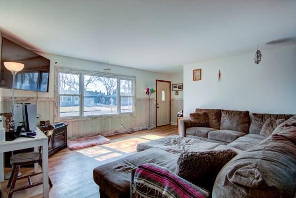 living area with wainscoting and wood finished floors