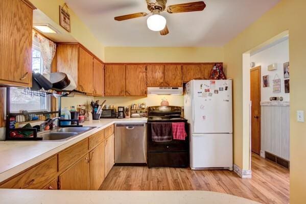 kitchen featuring under cabinet range hood, dishwasher, light countertops, freestanding refrigerator, and black electric range