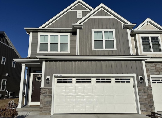 view of front facade with concrete driveway, stone siding, and an attached garage