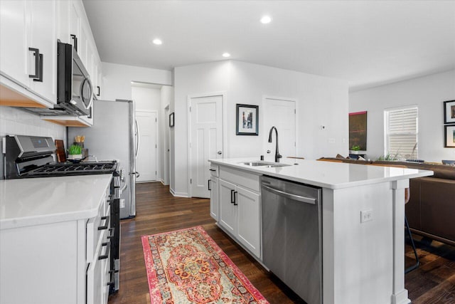 kitchen featuring white cabinets, an island with sink, appliances with stainless steel finishes, light countertops, and a sink