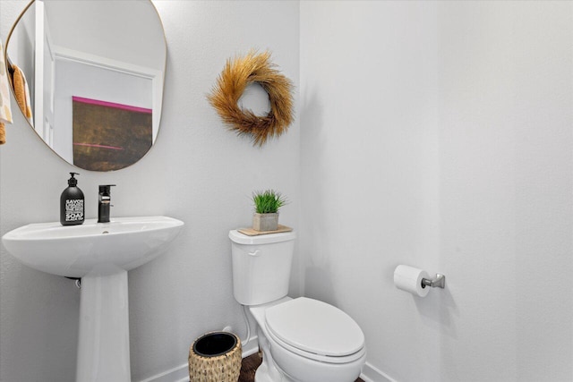 bathroom with toilet and baseboards