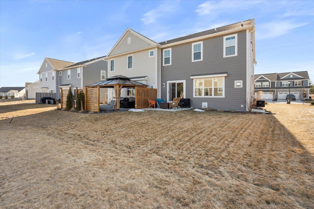 back of property featuring a residential view, a patio area, fence, and a gazebo