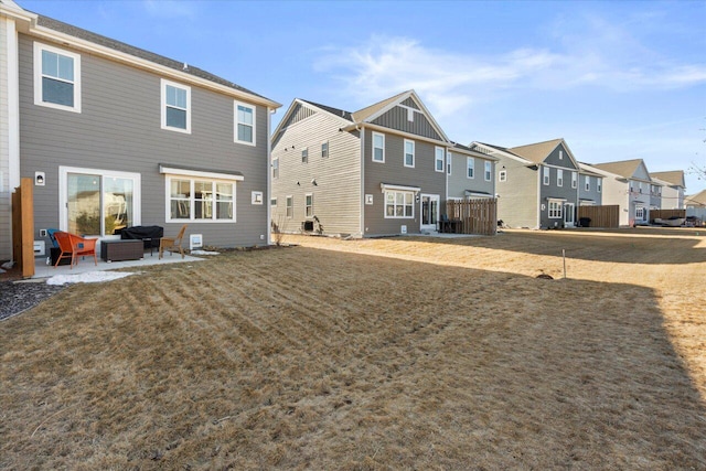 rear view of property featuring a residential view, outdoor lounge area, a patio, and a lawn