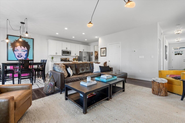 living area with light wood-type flooring, baseboards, and recessed lighting