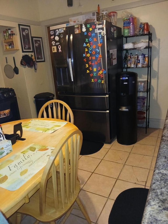 kitchen with tile patterned flooring and black fridge with ice dispenser